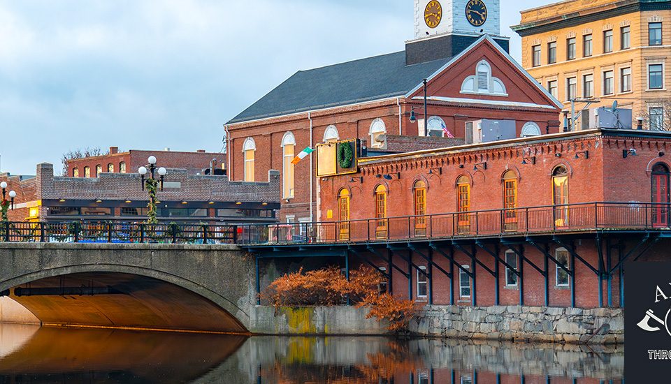outdoor scenery of brick buildings, a bridge and river in the city of Nashua, NH