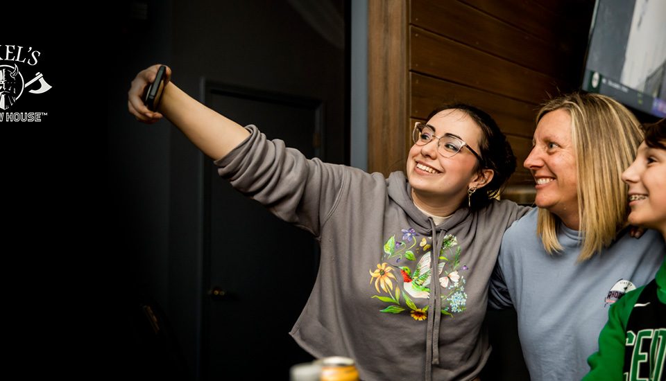 mom and two teens posting for a selfie at Axel's Throw House